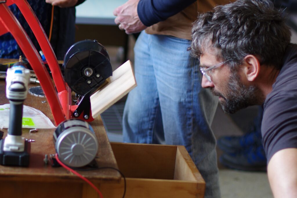 Dan checks the wheel pulley thing to convert bike power to electricity