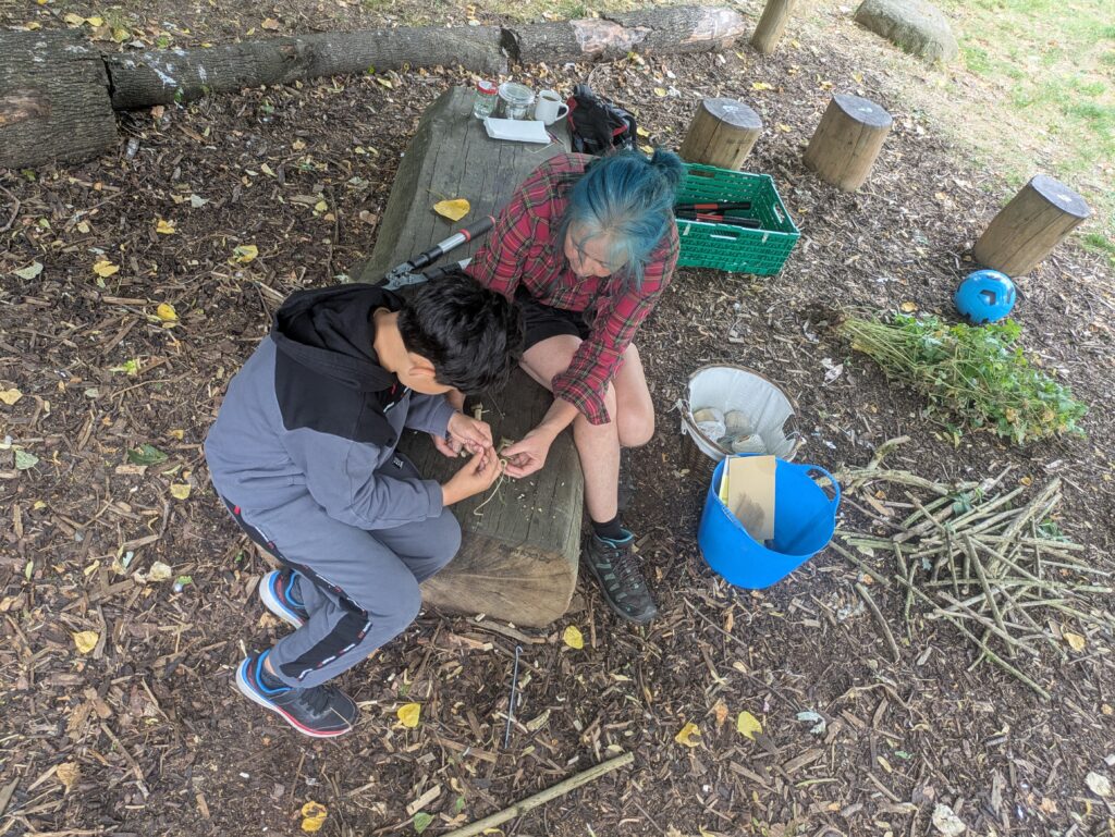 Ali guides a young wood carver